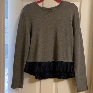 J Crew grey women’s sweatshirt with navy ruffle hem.